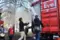 Menschen in der Nähe eines PublicEye-Containers beim Entladen von Waren